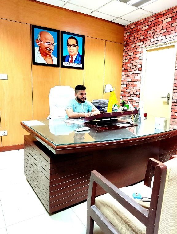 Founder of Azeem Wallpapers explaining wallpaper patterns to customer in showroom